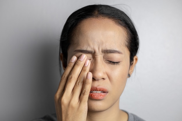 Woman suffering from strong eye pain.