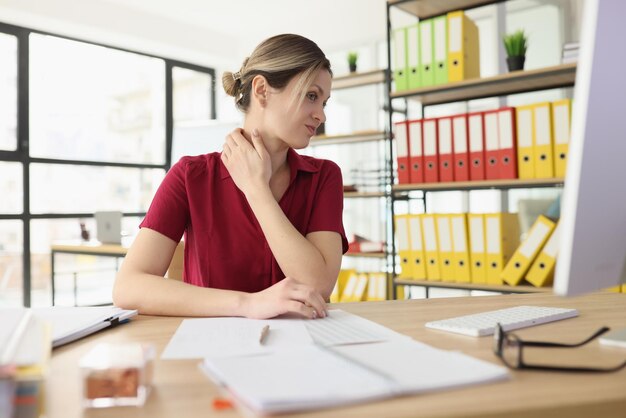 Woman suffers from pain in neck in company office closeup impact of overworking on employee