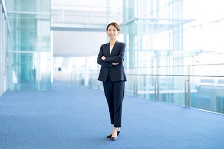 Photo スーツを着た女性がガラスの壁の前に立っています