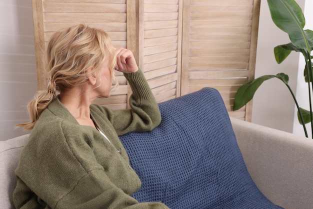 Woman sulking on sofa in living room Loneliness concept