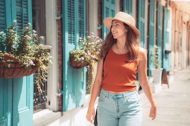 Photo a woman in a sun hat strolls along the street in summer happy smiling