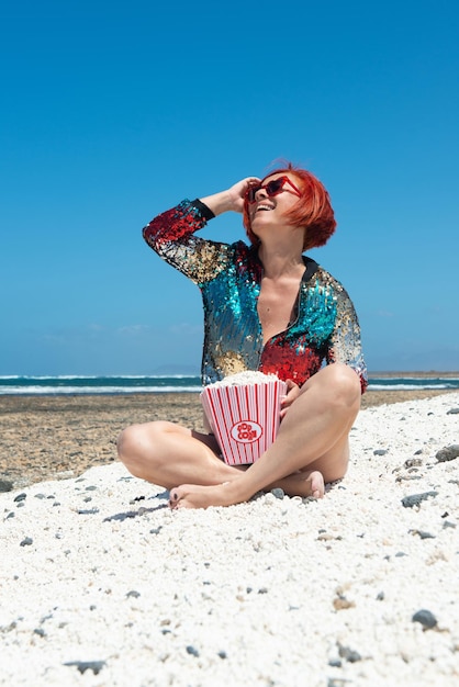 푸에르테벤투라의 팝콘 해변 모래 위의 태양 아래 있는 여자