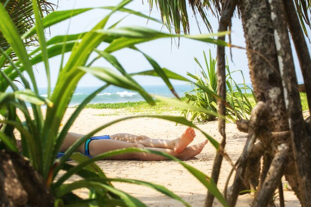 Foto donna che prende il sole vicino all'oceano