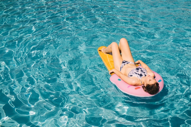 Фото Женщина загорать на надувной матрас в бассейне