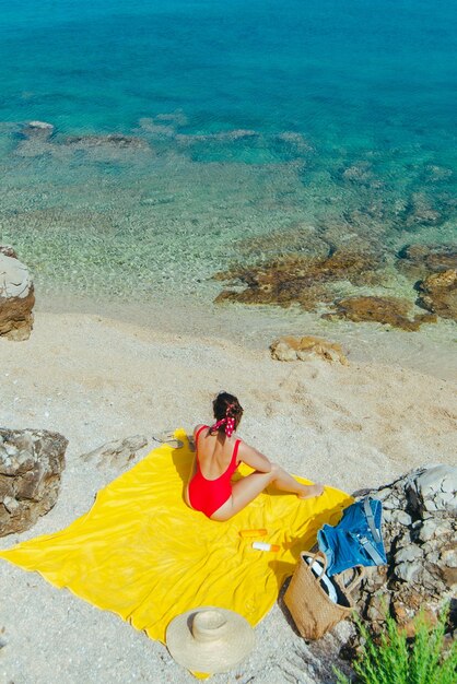 Woman sunbathing at sea beach in sunny day