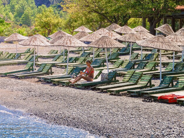 Woman on a sunbed under a beach umbrella.