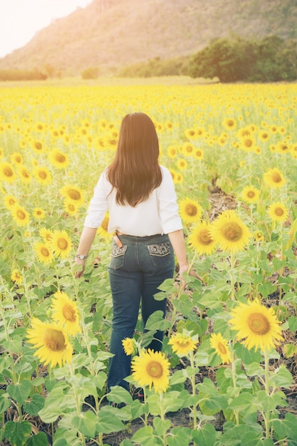 Woman in sunflower field. Healthy food product.