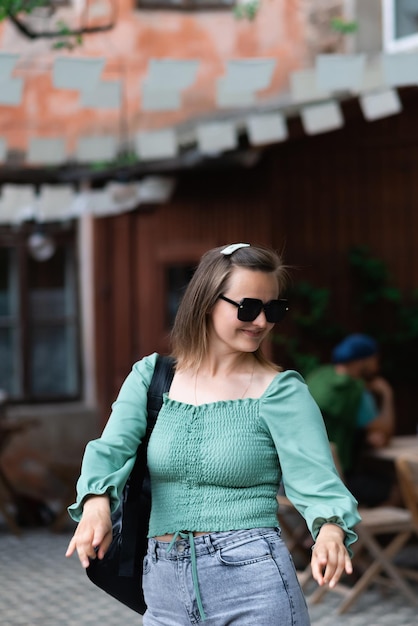 A woman in sunglasses is dancing on the street