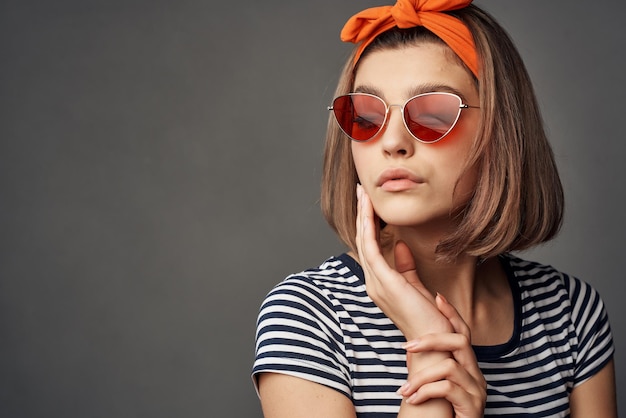 Woman in sunglasses with an orange bandage on her head in a striped tshirt fashion