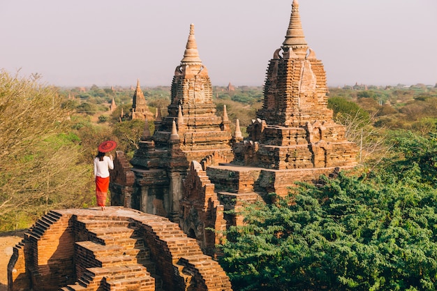 Woman in the sunset gazing at Buddhist pagodas