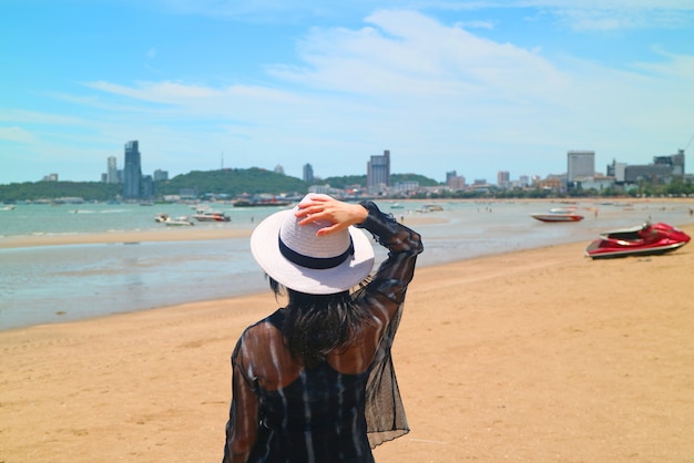 Woman on the sunshine beach looking at the sea