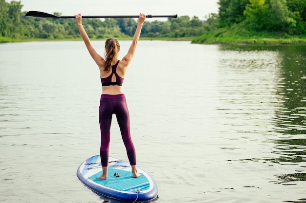 Woman on sup sup board in nature at evening