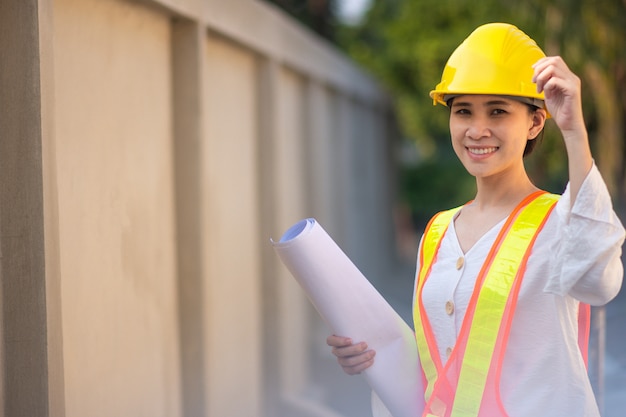 Woman Supervisor hard hat safety suit holding blueprint inspection building estate construction,Working woman