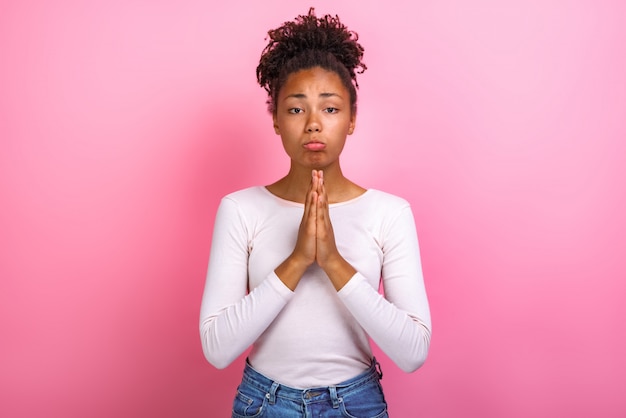 woman in supplication pose over pink