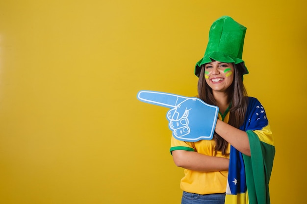 Woman supporter of brazil world cup 2022 pointing with foam finger to the left