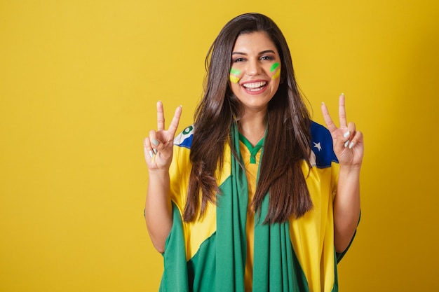 Woman supporter of Brazil world cup 2022 soccer championship using brazil flag as cover Peace and love