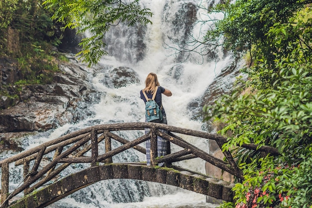 Woman in the surface of beautiful cascading Datanla waterfall In the mountain town Dalat, Vietnam