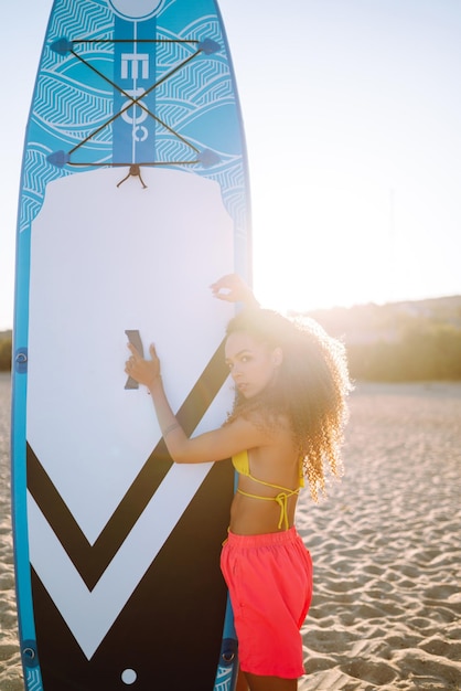 Photo woman surfer walks with a board on the sandy beach extreme sport travel weekend lifestyle