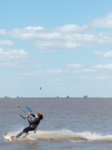 Photo woman surfing in sea against sky