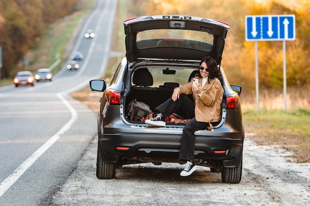 A woman surfs on her smartphone in trunk