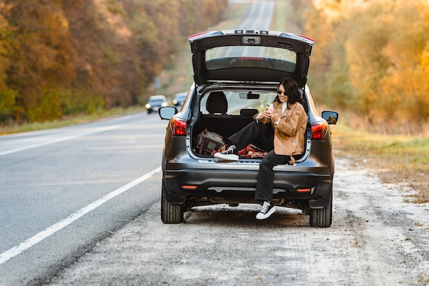 A woman surfs the web in the trunk of her car