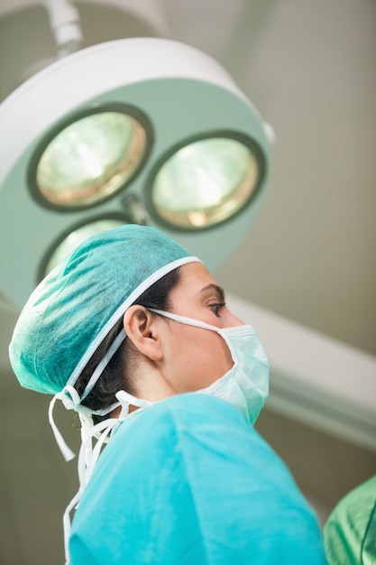 Woman surgeon under a surgical light