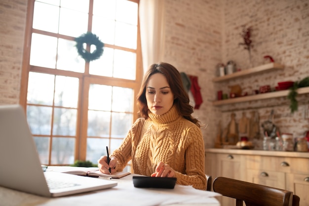 Woman in sweater working on a laptop