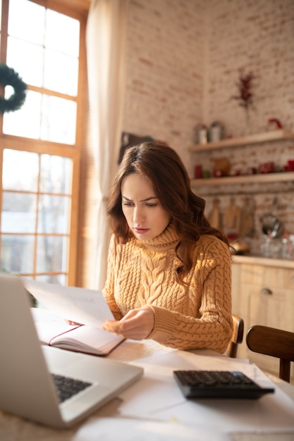 Woman in sweater working on a laptop