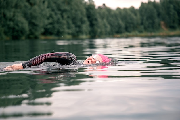 Woman swimmer conducts a workout in the lake