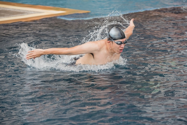 Woman swimming the butterfly stroke in a swimming pool.