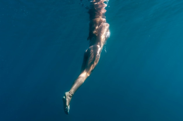 Foto donna che nuota sotto l'oceano