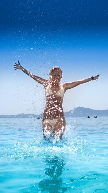 Woman swimming in pool against sea