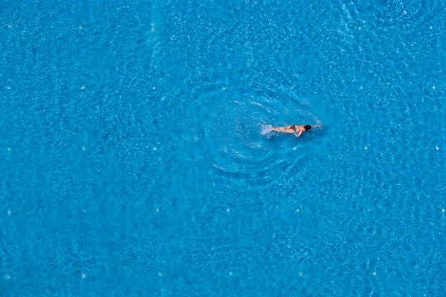 Woman swimming in a pool top view