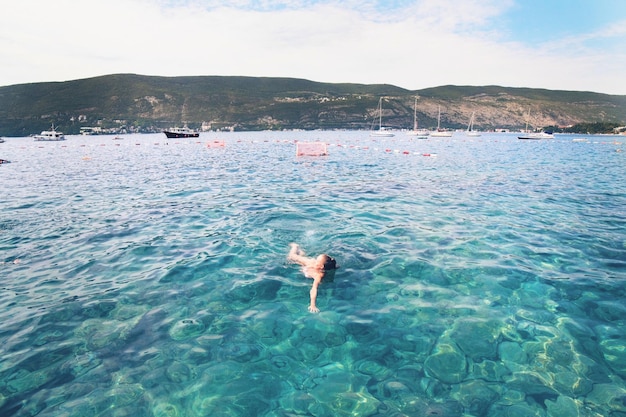 Photo woman swimming in sea against mountains