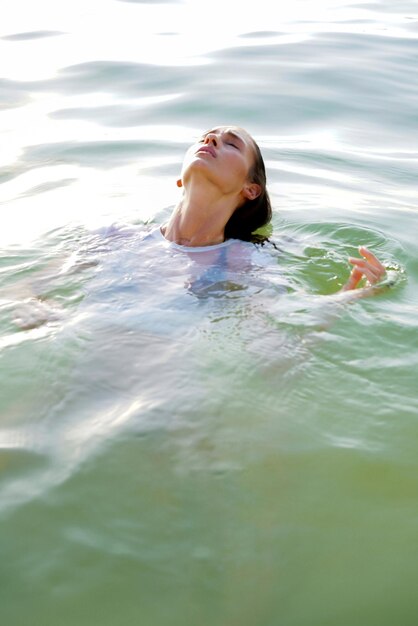 Woman swimming in the sea at sunset