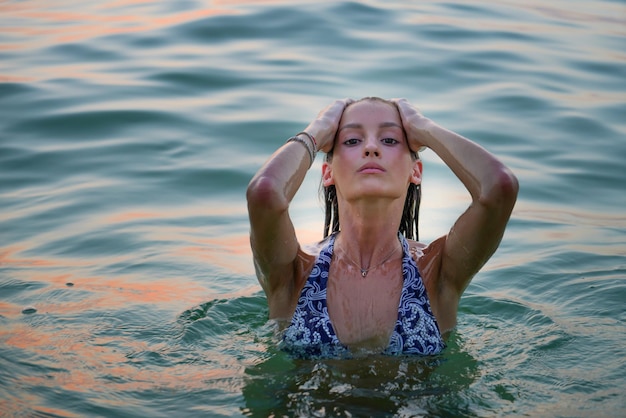 Photo woman swimming in the sea at sunset