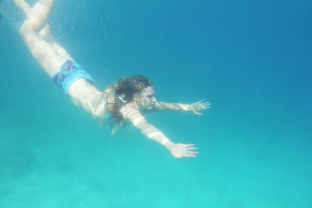 Foto donna che nuota sott'acqua nel mar adriatico mediterraneo in croazia