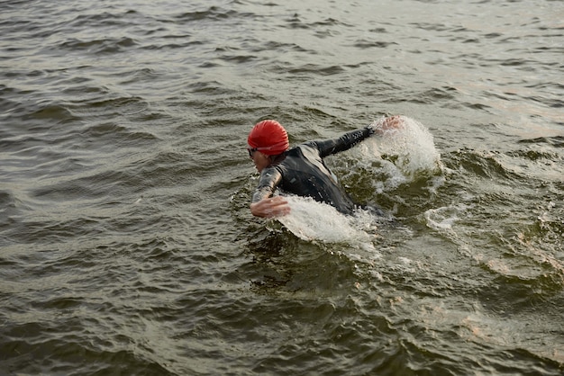 Женщина в купальнике плывет по озеру во время соревнований
