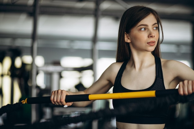 Woman sxercising at the gym using stretch ropes