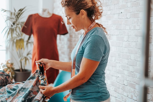 Woman in tailor activity at home or design studio store Workshop of tailoring Adule female working with textile and mannequin in background Stylist lady creating clothes and enjoy hobby indoor