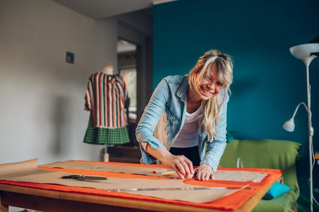 Woman tailor working from home and tailoring beautiful
clothes