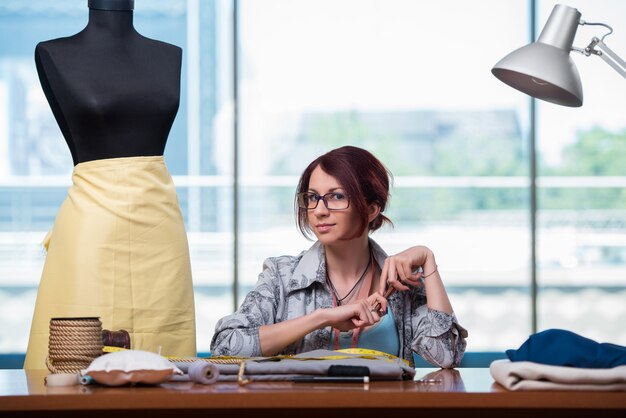 新しい服に取り組んでいる女性テーラー