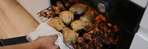 Woman take cooked chicken out of oven