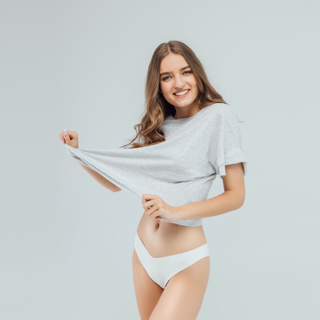 Woman take off t shirt from her perfect body