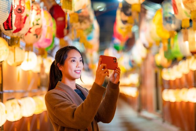 woman take photo on cellphone with lots of lantern
