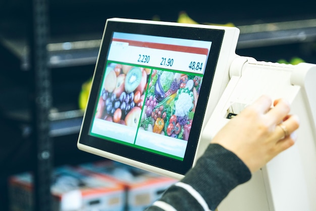 Woman take sticker with price after weigh products