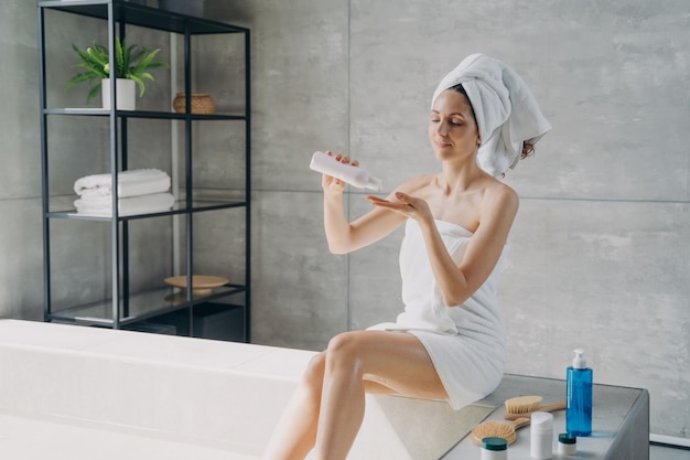 목욕 후 보습 천연 화장품을 사용하여 신체 피부를 관리하는 여성 스킨케어 트리트먼트