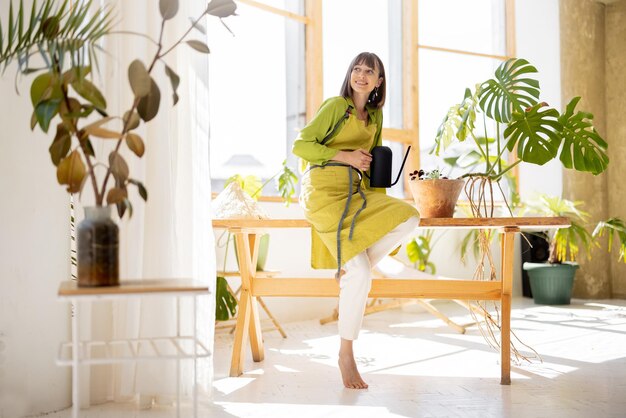 Photo woman takes care of green plants indoors