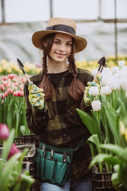 庭のチューリップの花の世話をする女性