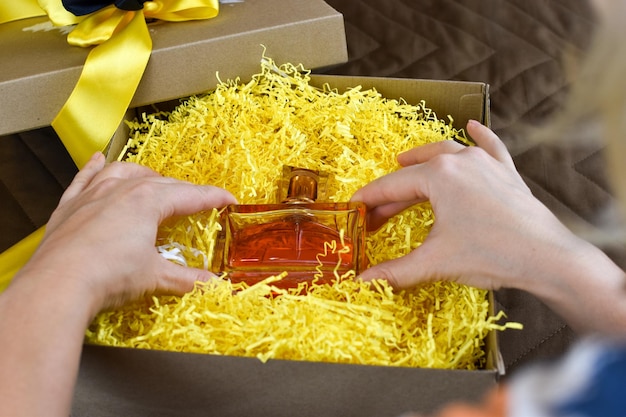 Woman takes fragrant perfume from a gift box. nice gift for a woman